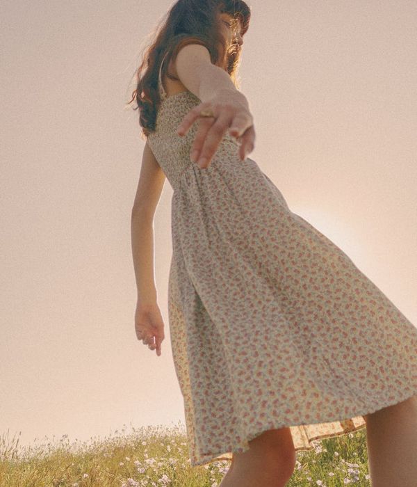 Woman performing a gentle, flowing cardio movement in a bright, airy space.